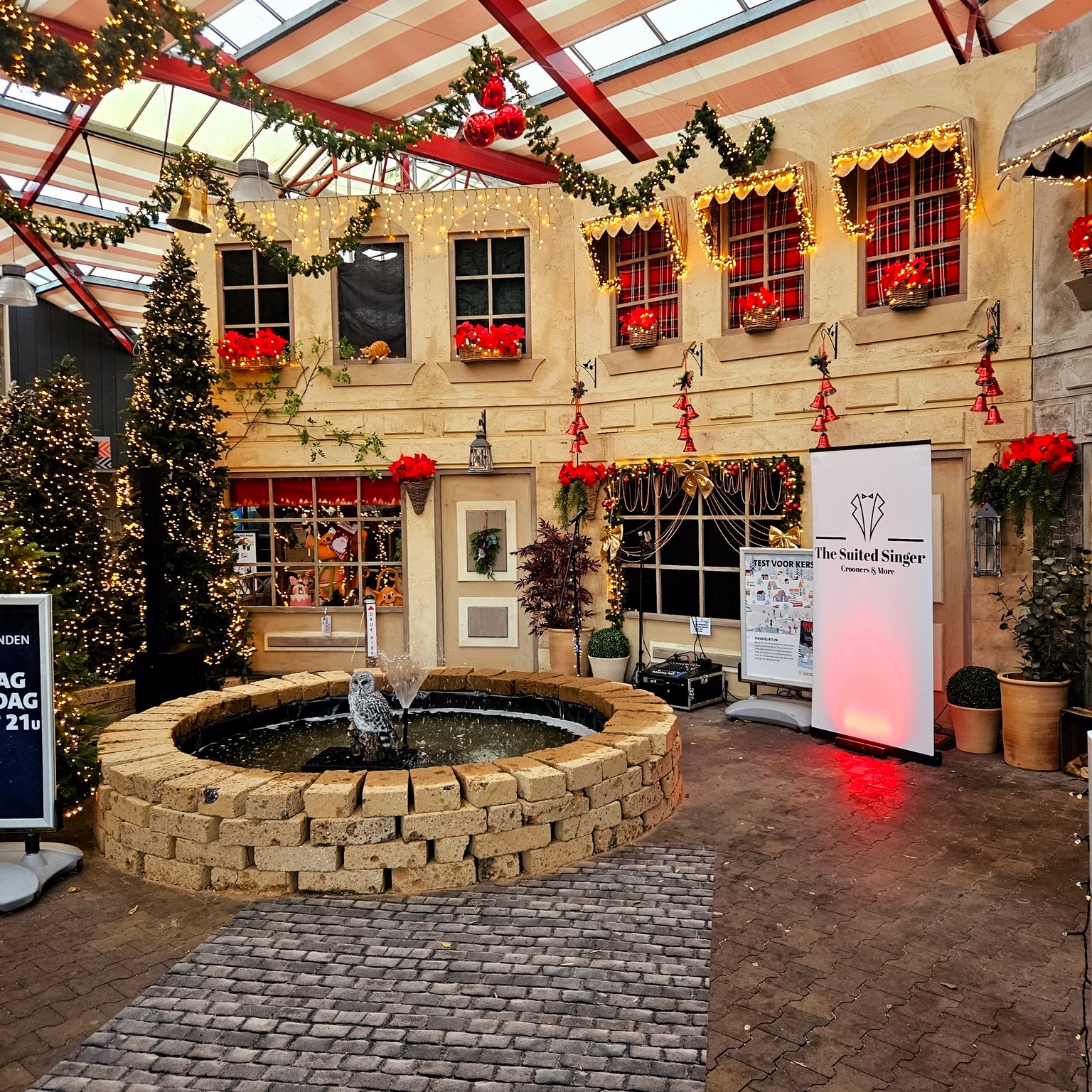 Opstelling van de kerstact in een aangekleed kerstdorp met verlichte kerstbomen